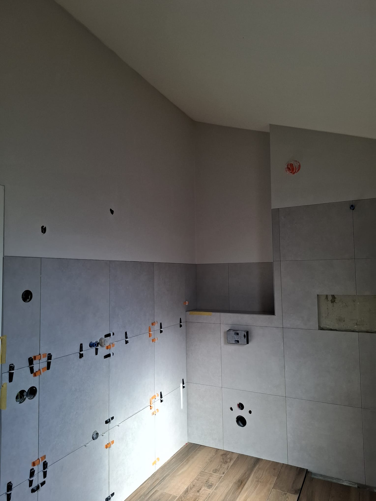 Badkamerwand strak afgewerkt met nette overgang naar tegels