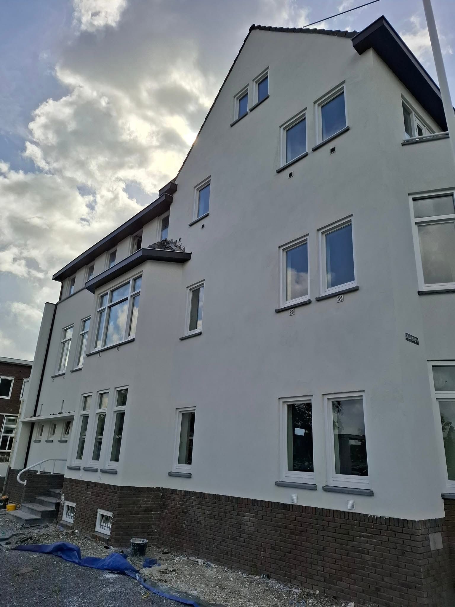 Hoekpand — voorgevel met erker, strak pleisterwerk